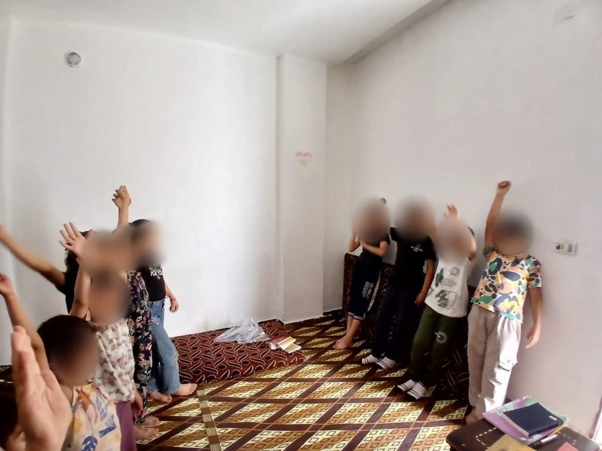 Children worshipping with hands raised in a house church